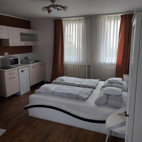 a bedroom with two beds and a kitchen at Petra Vendégház in Szekszárd