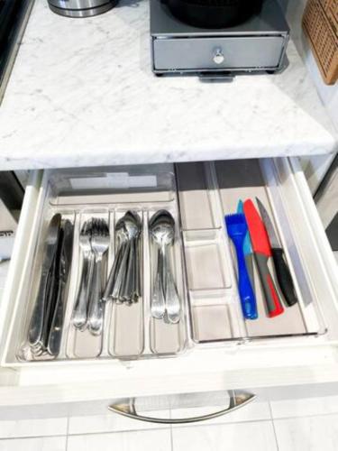 a drawer in a refrigerator filled with utensils at Inspired Stay close to Niagara *4B & 2King Beds* in Thorold