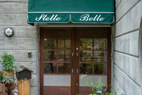a green awning over the doors of a flower shop at Hotel Stelle Belle in Hakuba