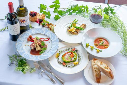 a table with plates of food and a bottle of wine at Hotel Stelle Belle in Hakuba