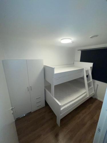 Family-Friendly Apartment close to the beach في Rød: غرفة بها رف أبيض وخزانة بيضاء