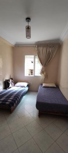 a bedroom with two beds and a window at Appartement de vacances in El Jadida