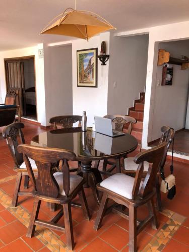 a dining room with a table and chairs with a laptop at Rustico Hostel Barichara in Barichara