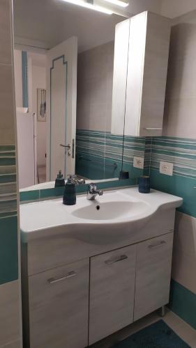 a bathroom with a white sink and a mirror at Casetta Emilia vicino al mare in Ischia