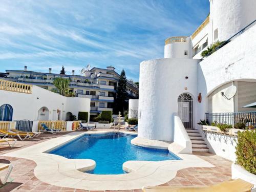 a swimming pool in a courtyard with a building at Apartamento Relax y Golf in Mijas