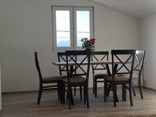 a dining room table and chairs with a vase of flowers on it at Cozy, Fully Equipped, Free parking&Wifi, Quiet, 2BD in Podgorica