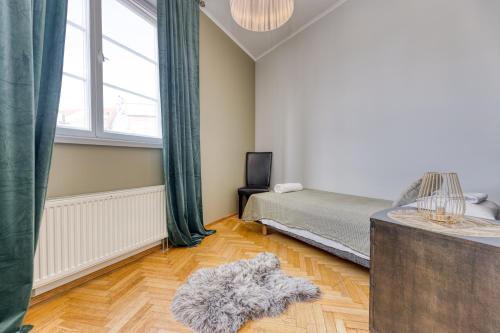 a bedroom with a bed and a large window at Historic Residence Apartments at Old Town in Tallinn