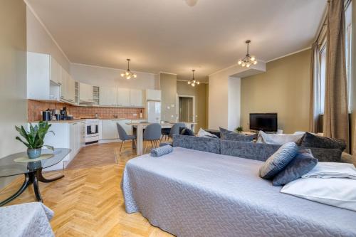 a living room with a large bed and a kitchen at Historic Residence Apartments at Old Town in Tallinn