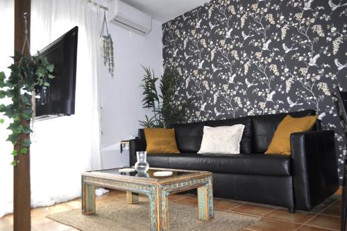 a living room with a black couch and a table at Azahares Apartamento turístico in El Bosque