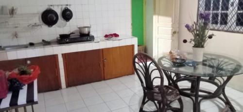 eine Küche mit einem Tisch, 2 Stühlen und einer Theke in der Unterkunft Villa kemuning in Kopo 2