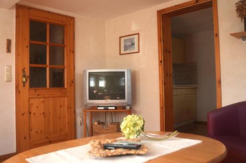ein Wohnzimmer mit einem TV und einem Tisch in der Unterkunft Ferienwohnung Vorndran in Bischofsheim an der Rhön