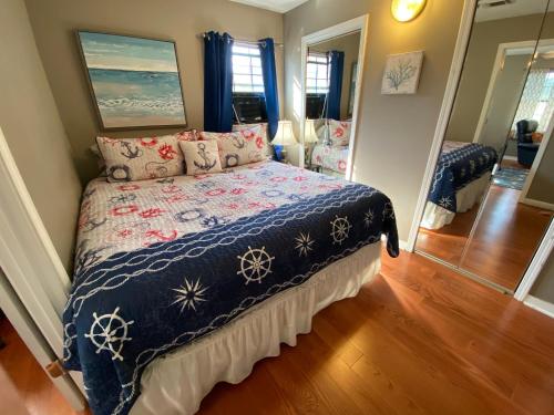 a bedroom with a bed with a blue comforter at Pelican Nest-Heated Pool Jacuzzi Tub Pvt Balcony in Pensacola
