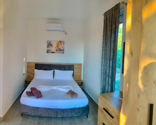a bedroom with a bed and a window at Natyra e Ishullit -Resort- in Ishull-Shëngjin