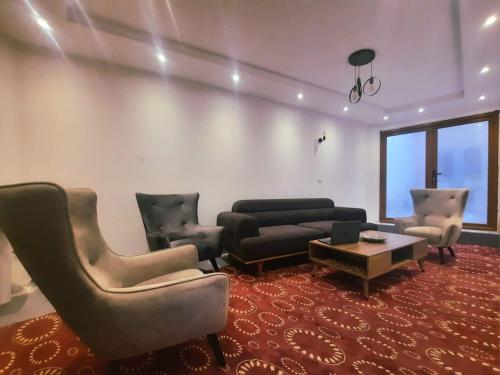 uma sala de estar com um sofá, cadeiras e uma mesa em Comfort Hotel Prizren em Prizren