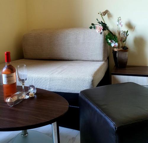 um quarto com uma garrafa de vinho e uma mesa em КАРИАНА хотел 