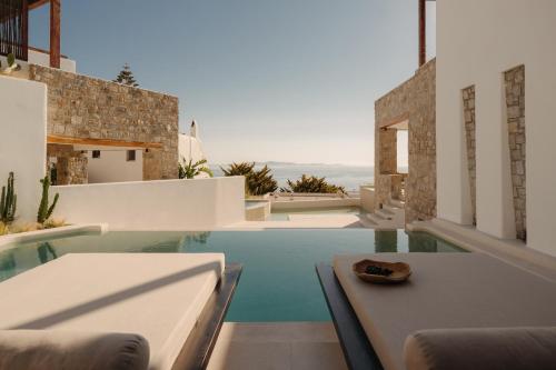 - une piscine dans une maison avec une table et des chaises dans l'établissement Bard De Sol, à Mykonos