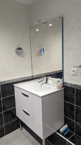 une salle de bain avec un lavabo blanc et un miroir dans l'établissement Les Salins à Sète proche plages, à Sète