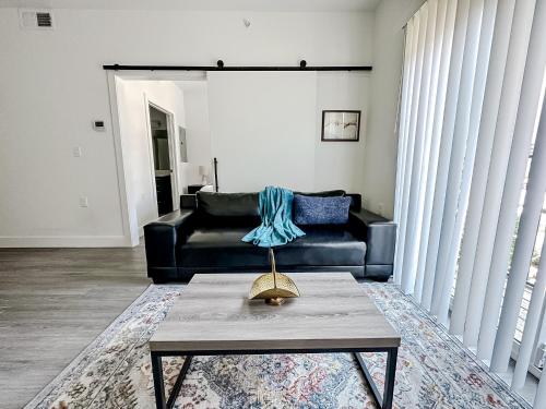 a living room with a black couch and a table at Sleepover Trendy Downtown Springfield Apartments in Springfield