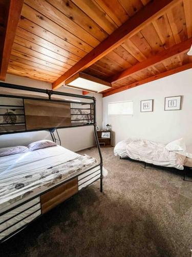 a bedroom with two bunk beds and a wooden ceiling at Retreat Home Near Yosemite and Bass Lake! in Oakhurst