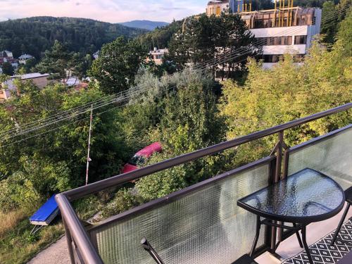 a balcony with a table and a view of a city at Vila Kysuca in Luhačovice