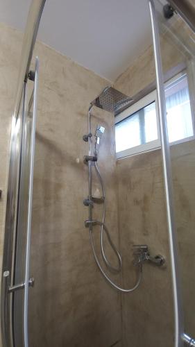 y baño con ducha y manguera. en Flowers Guesthouse en Tirana