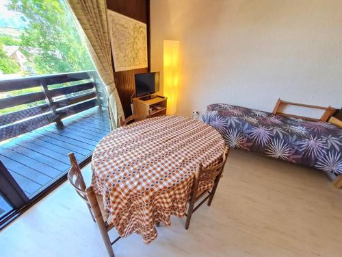 a room with a table and a bed and a balcony at Belle vue au château d'Ancelle in Ancelle