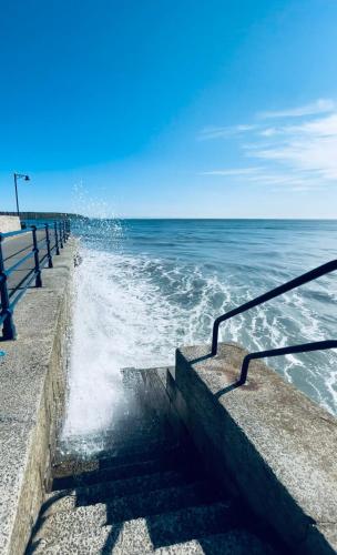 a stairway leading into the ocean with the waves at Boardwalk@TheBay, Filey in Filey
