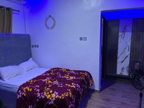 een slaapkamer met een bed met een paars licht bij The Casterwells in Ibadan