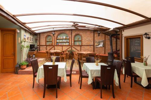 a dining room with tables and chairs and a brick wall at Dallia Loft Space in Goumenissa