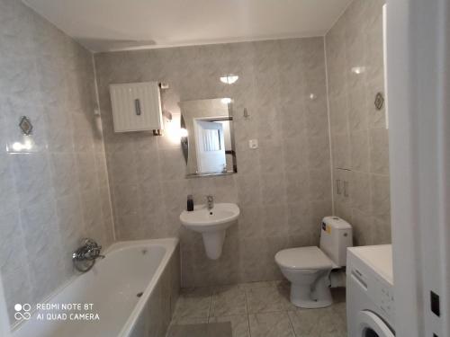 a bathroom with a sink and a toilet and a bath tub at Kawalerka na Ślichowicach in Kielce