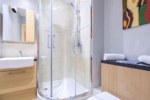 a bathroom with a shower and a sink at Glamorous Central Apartment in London