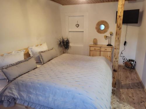 a bedroom with a large bed and a television at Naturoase in Inzigkofen