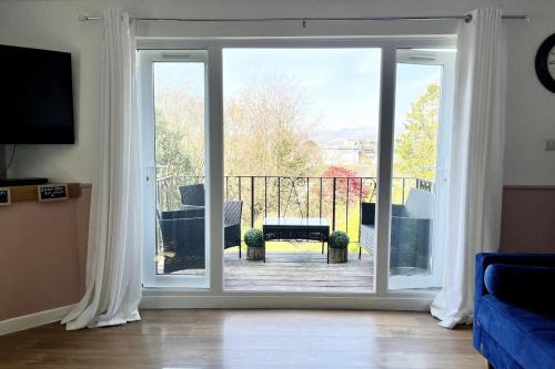a living room with a sliding glass door to a balcony at Windermere Lake view Hideaway Pet friendly nearby Lake parking golf nearby walkers welcome in Bowness-on-Windermere