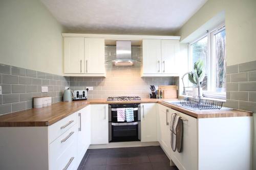 a kitchen with white cabinets and a stove top oven at Windermere Lake view Hideaway Pet friendly nearby Lake parking golf nearby walkers welcome in Bowness-on-Windermere