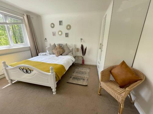 ein Schlafzimmer mit einem weißen Bett und einem Stuhl in der Unterkunft Pet Friendly, Lake View, Parking, Golf Nearby in Bowness-on-Windermere