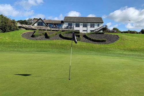 a putting green with a flag in front of a house at Windermere Lake view Hideaway Pet friendly nearby Lake parking golf nearby walkers welcome in Bowness-on-Windermere