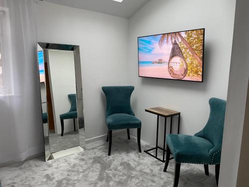 a waiting room with chairs and a tv on the wall at 5 min from the beach ,parking in Guest House in Bournemouth