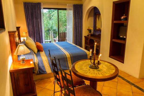 a bedroom with a bed and a table and a window at Hotel Lunata - 5th Avenue in Playa del Carmen