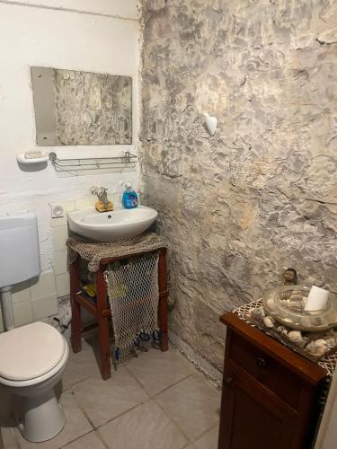 a bathroom with a white toilet and a sink at Holiday home Stiniva in Vis