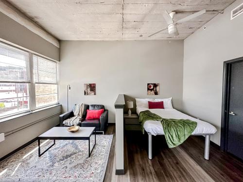 ein Schlafzimmer mit einem Bett und einem Sofa in der Unterkunft Sleepover Luxe Downtown Springfield Apartments in Springfield