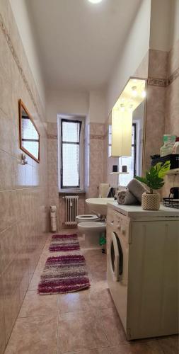 ein Badezimmer mit einer Waschmaschine und einem Waschbecken in der Unterkunft Ottimo appartamento " Pala Alpitour" in Turin