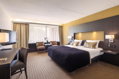 a hotel room with a bed and a desk at Van der Valk Hotel Goes in Goes