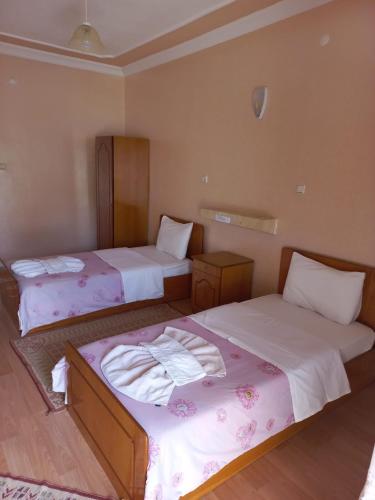 a room with two beds with towels on them at Akar Hotel in Ihlara