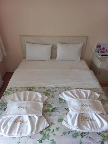 a bed with white sheets and pillows on it at Akar Hotel in Ihlara
