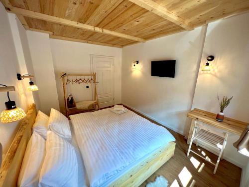 a bedroom with a large bed with a wooden ceiling at Victoria Gasthaus Rasnov - charming vacation house in Rasnov in Râşnov