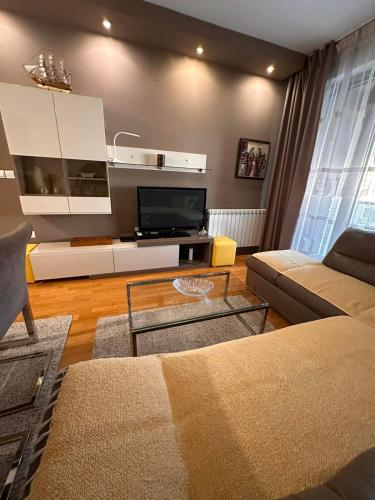 - un salon avec un canapé et une télévision dans l'établissement Dono apartment, à Skopje