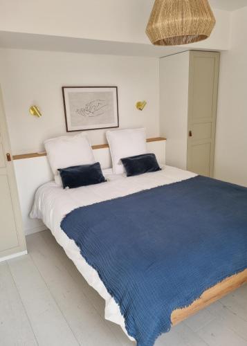 um quarto com uma cama grande e 2 almofadas azuis em Victoire Saphir 203 climatisé hôtel de ville em Saint-Dizier