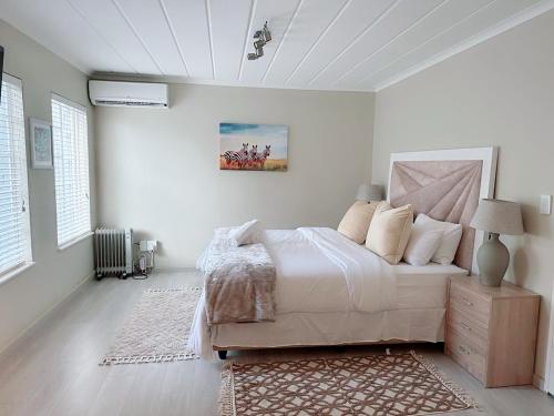 um quarto com uma cama grande e paredes brancas em Sammy's Nest em Joanesburgo