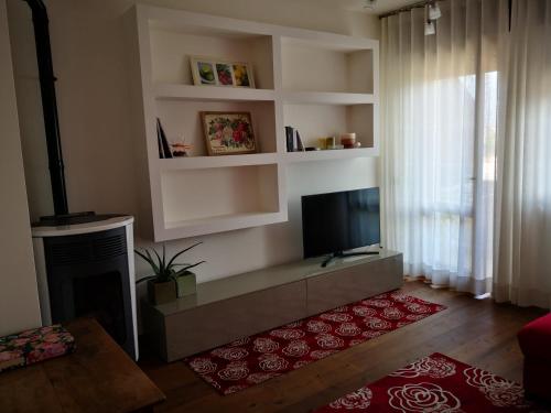 uma sala de estar com lareira e uma televisão de ecrã plano em Appartamento Al Parco em Belluno