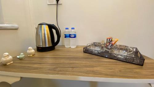 a counter with a coffee maker and water bottles on it at Stone house apart hotel in Arnavutköy